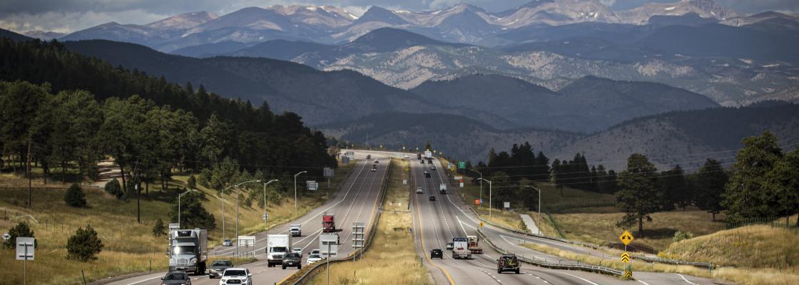 Scenic view of the Rocky Mountains in Colorado, looking west along Interstate 70 with cars traveling.